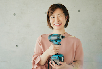電動ドライバーを持つ女性